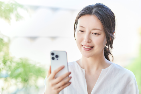 専用のiPhoneアプリから防犯カメラの映像を確認する女性の画像